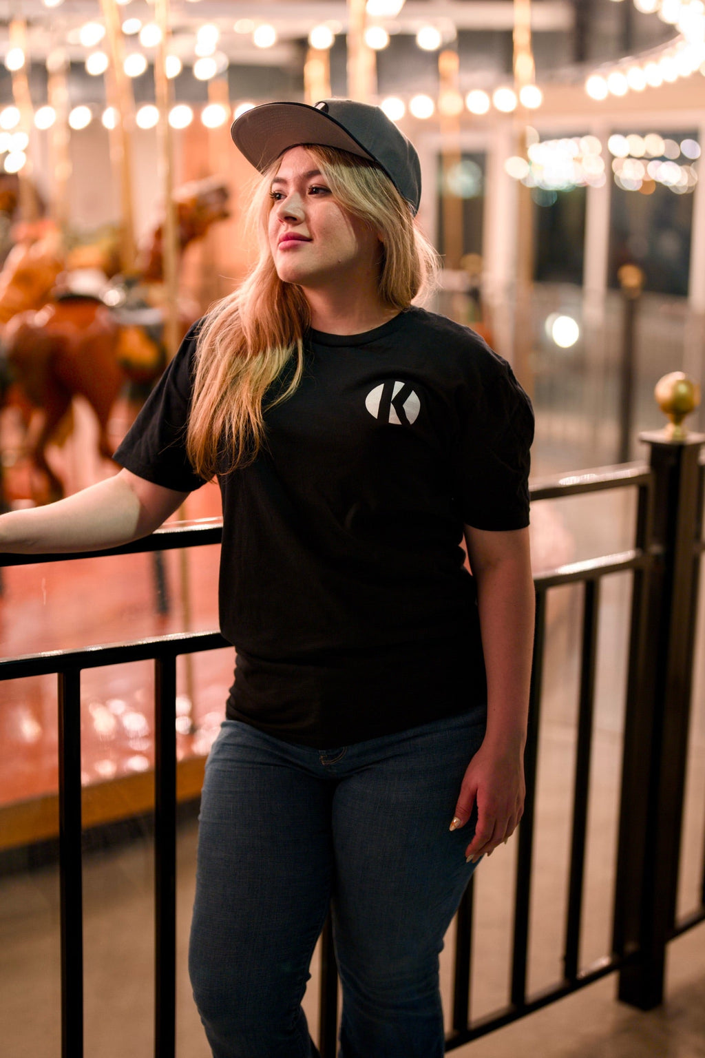 Woman wearing the black Kalaveras Heritage Los Novios Graphic Tee, front view at a Kalaveras restaurant