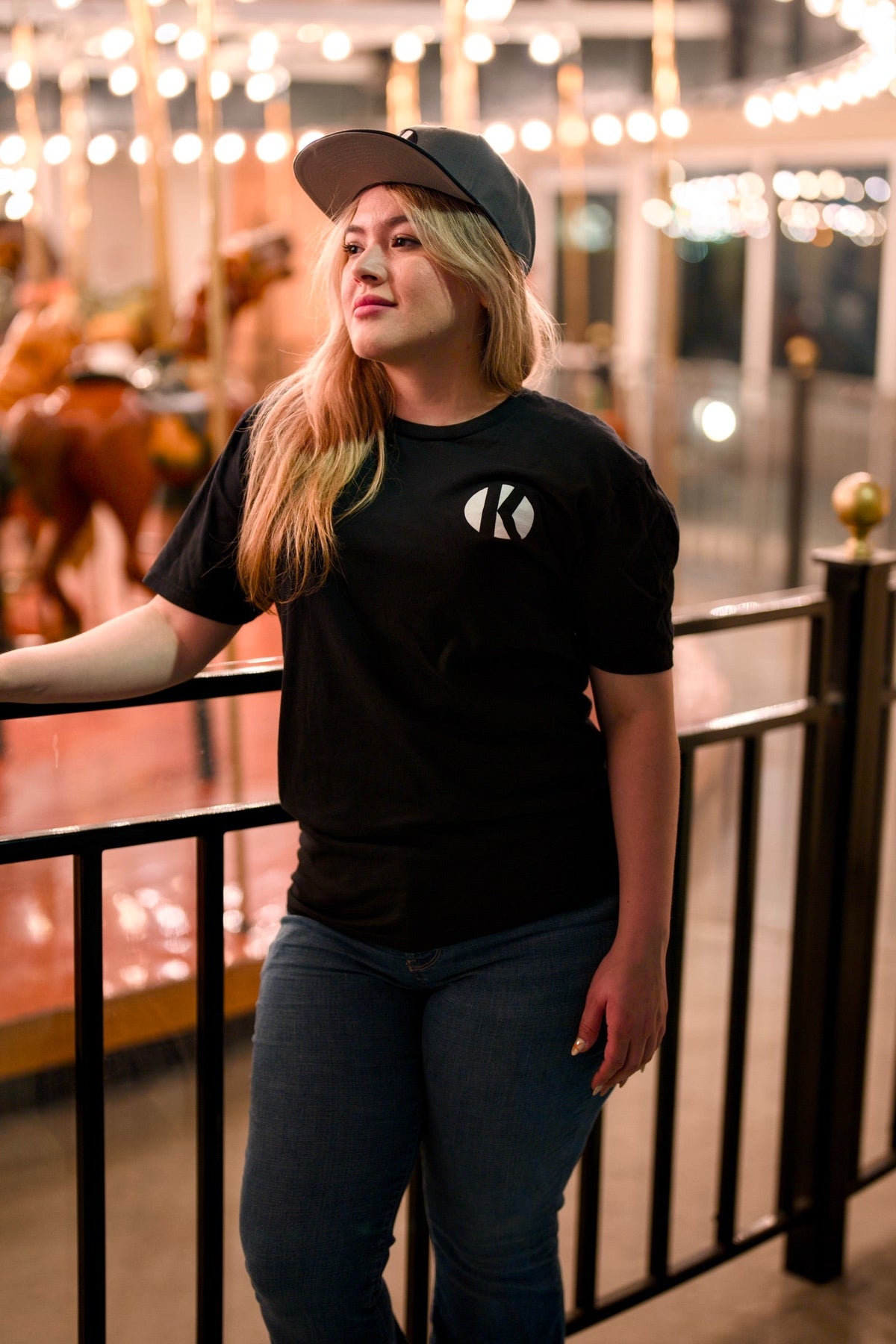 Woman wearing the black Kalaveras Heritage Los Novios Graphic Tee, front view at a Kalaveras restaurant