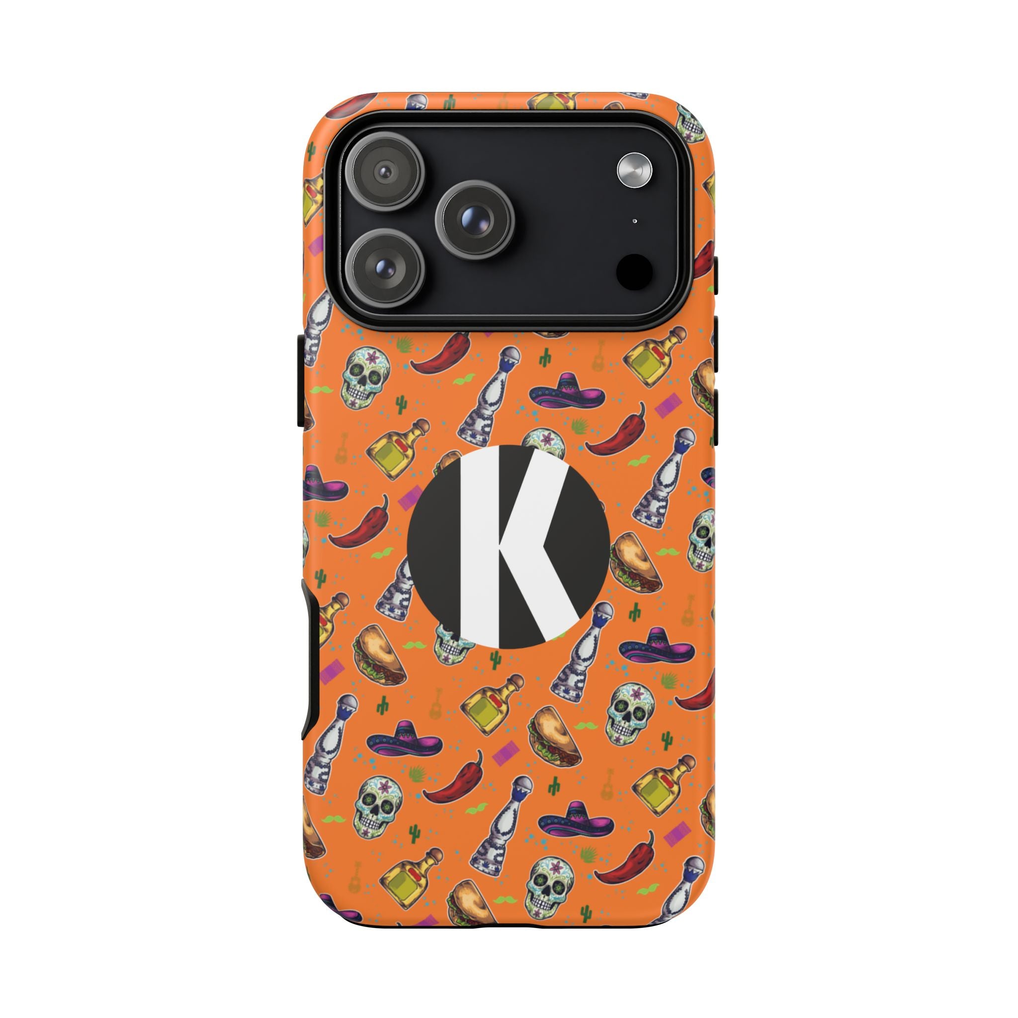 An orange phone case featuring a colorful Mexican-themed pattern with skulls, chili peppers, and tequila bottles, accented by a large black circle containing a white letter 'K' on the back.