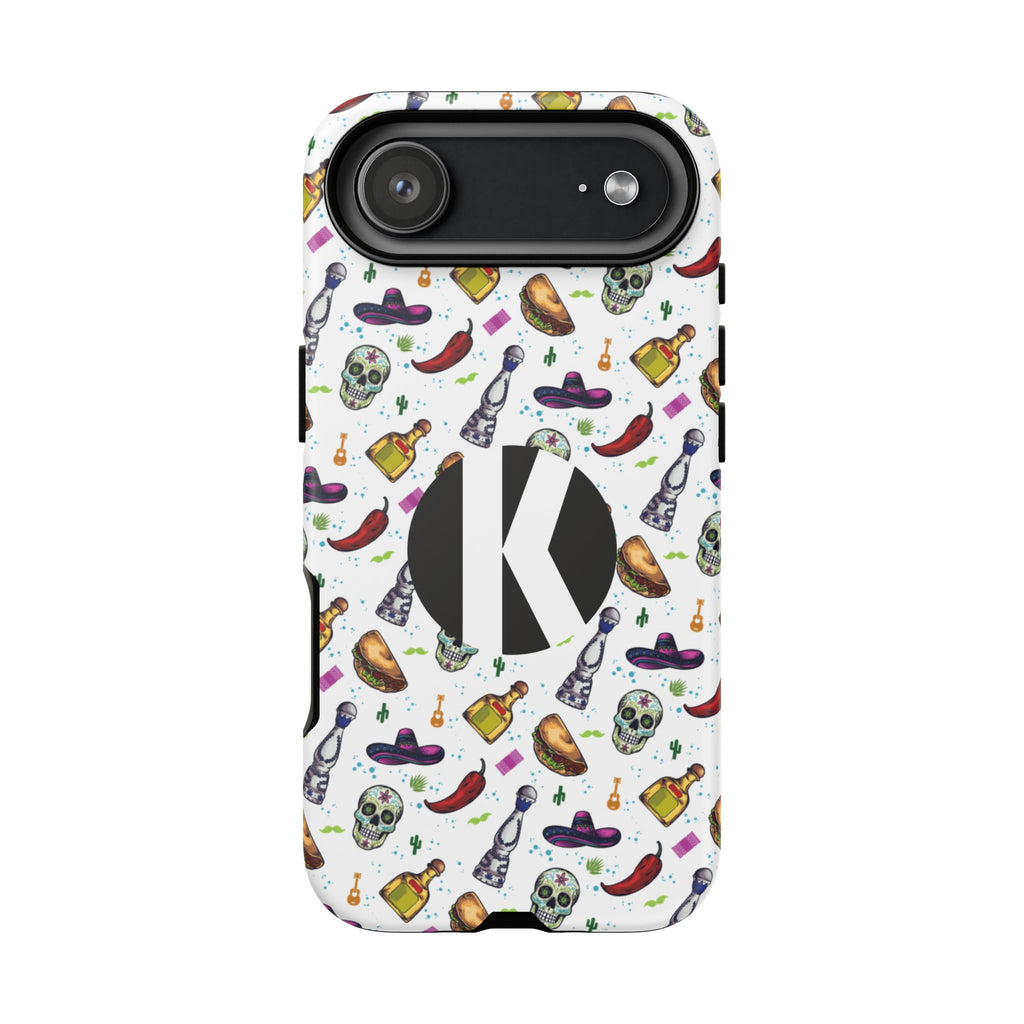 A white phone case with a colorful Mexican-themed pattern of sombreros, skulls, chili peppers, and tequila bottles, featuring a large black circle with a white letter K in the center.